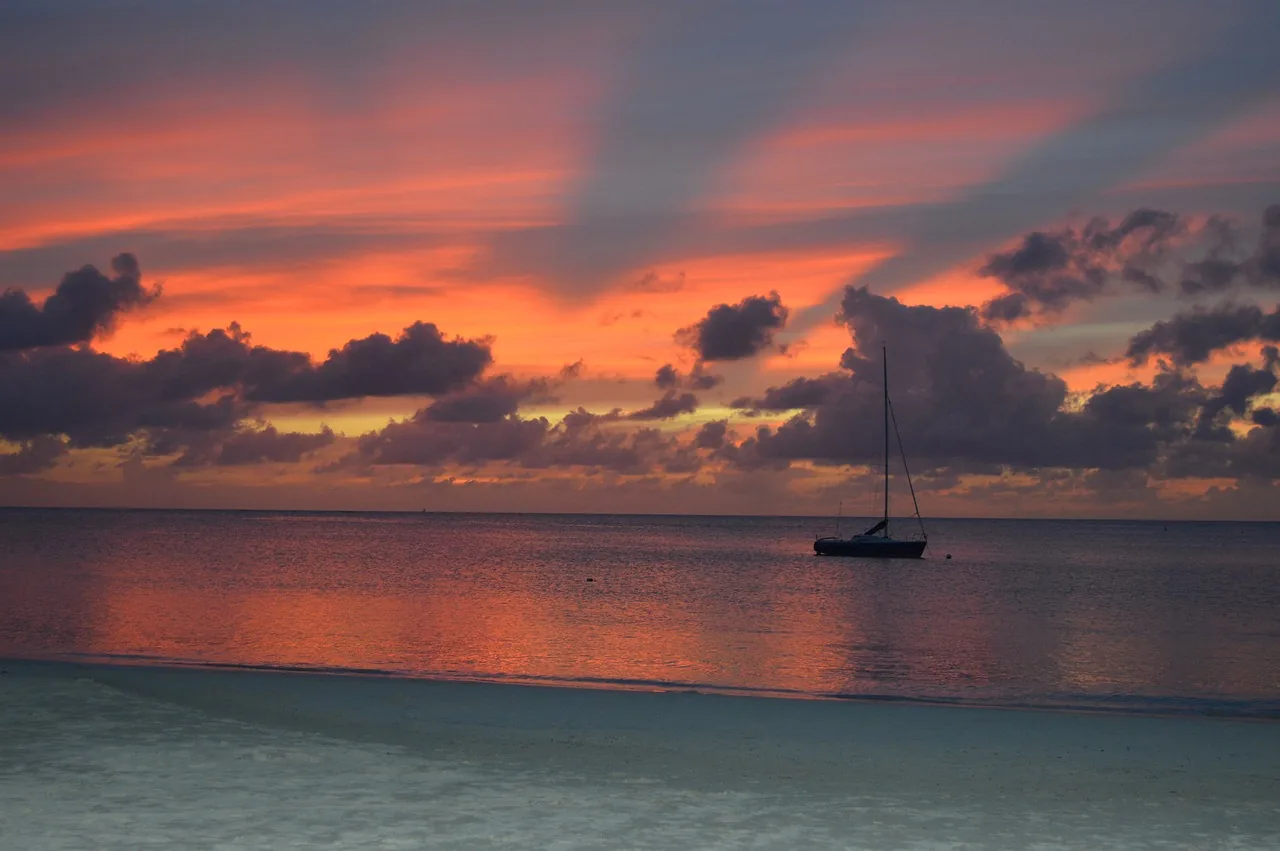 An orange and pink sunset over the Caribbean Sea at Dickenson Bay, Antigua